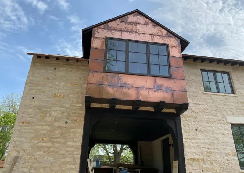 Copper metal panel facade on a stone building for Roof Repair in Burnet