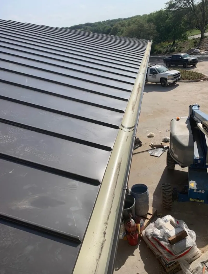 Standing seam panel and gutter detail on a metal roofing jobsite in Burnet